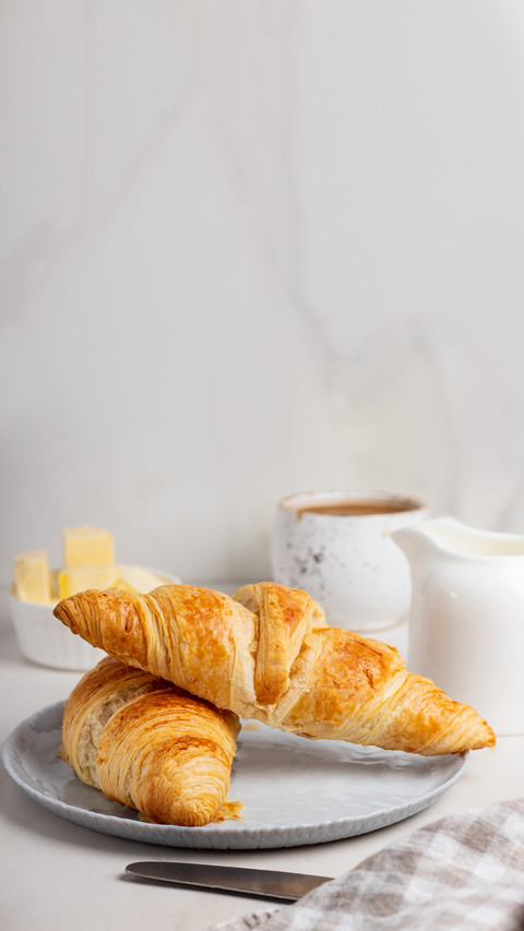 Fresh french croissants on plate and cup of coffee screenshot