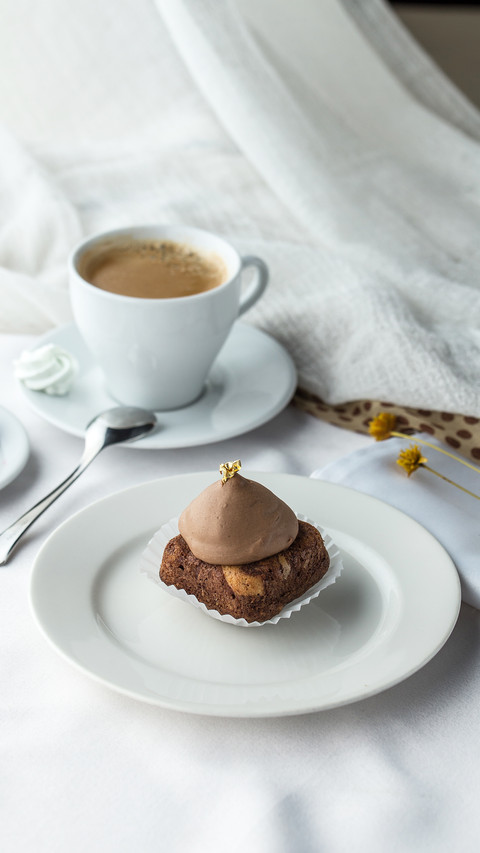 Side view of chocolate cake and coffee on white table screenshot