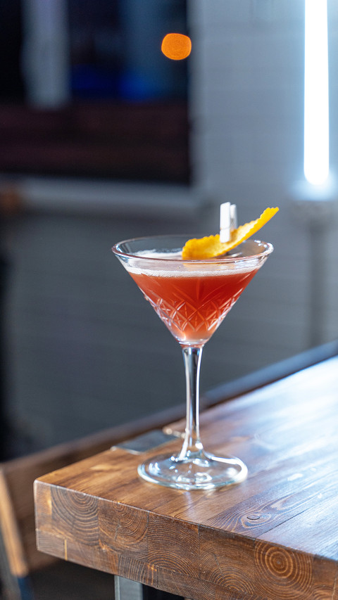 Cosmopolitan cocktail on wooden table screenshot