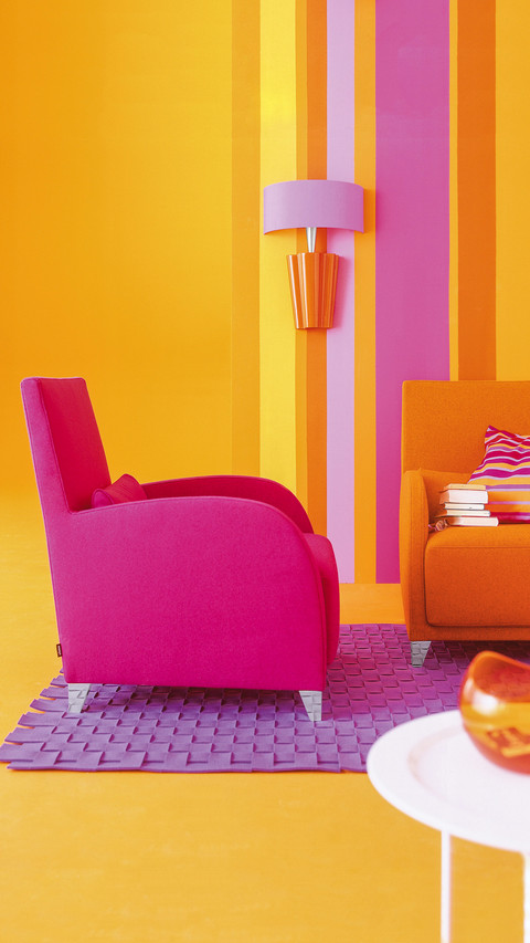 Pink armchair in front of striped wallpaper in living screenshot