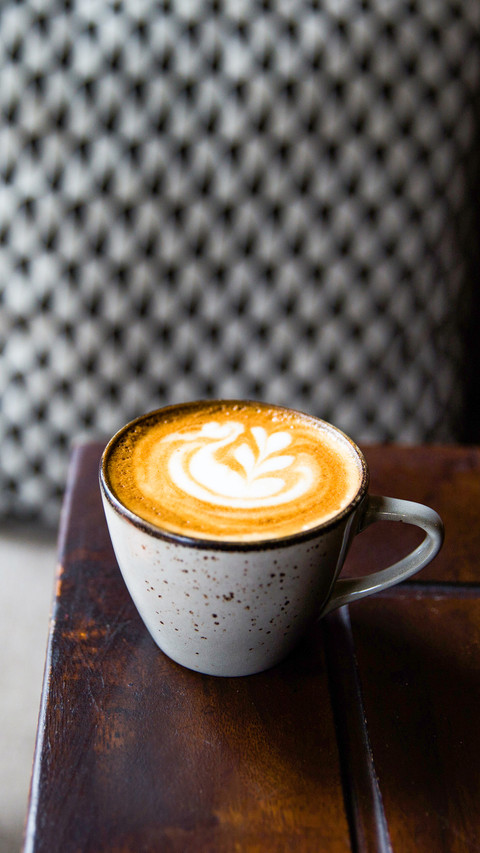 Two Cups of hot cappuccino on wooden desk with spoons screenshot