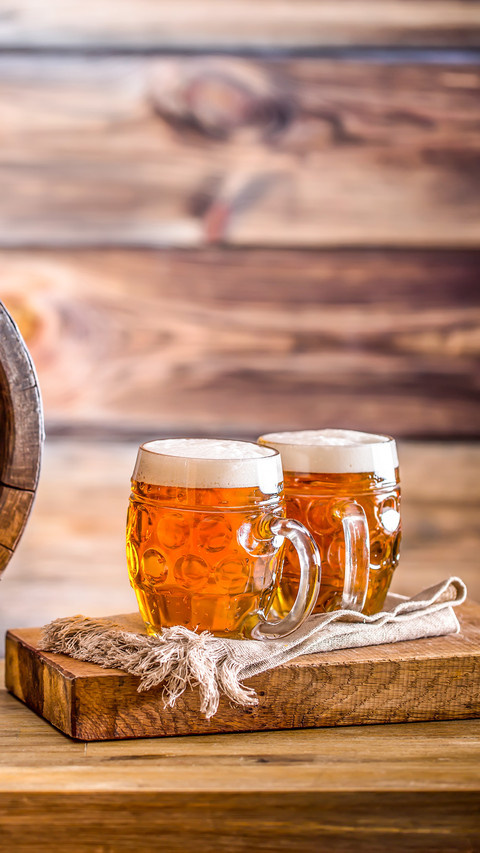Two glasses full of beer with wooden barel screenshot