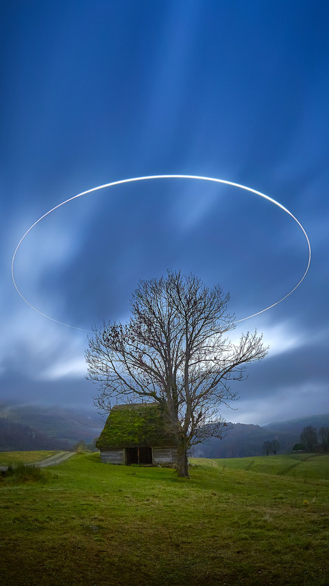 Landscape by night with circle of light over the hills screenshot