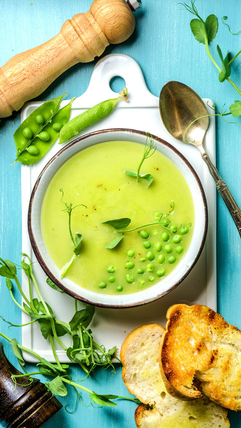 Light summer green pea cream soup in bowl with sprouts screenshot