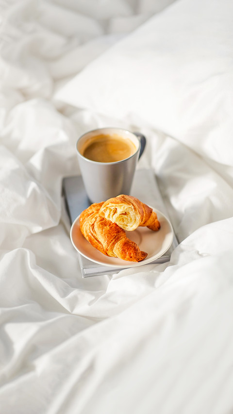 cup of coffee and book in bed at home screenshot
