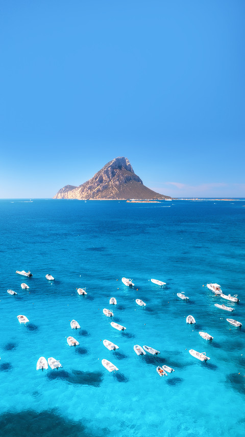 Aerial view of motorboats on blue sea at sunset in summer screenshot