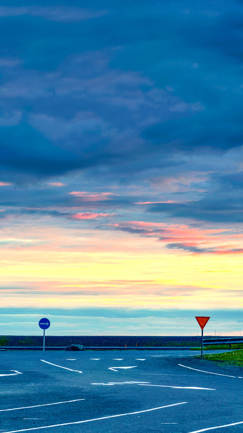 Concrete road with traffic signs and colorful cloud sky screenshot