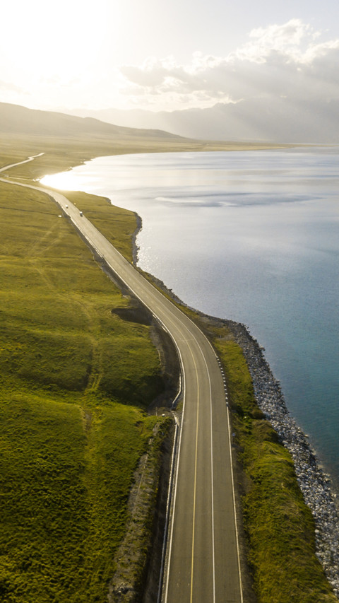 The lake and mountain scenery along the winding road screenshot