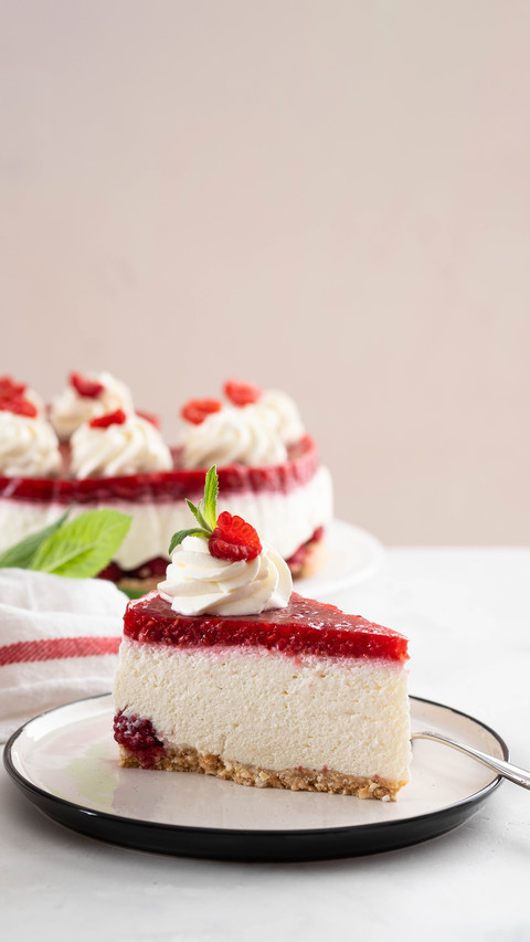 Cheesecake slice with fresh raspberries and mint leaves screenshot