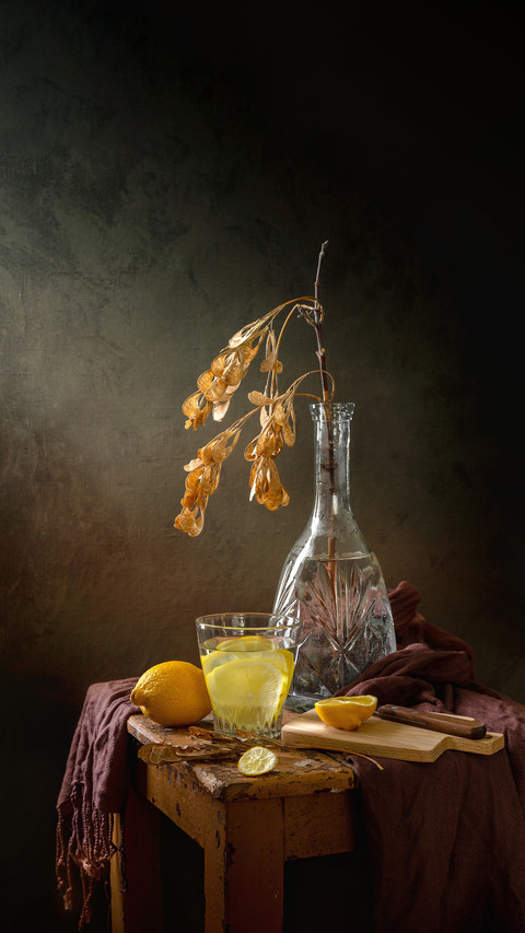 Still life with a cup of water with lemon and a maple branch screenshot