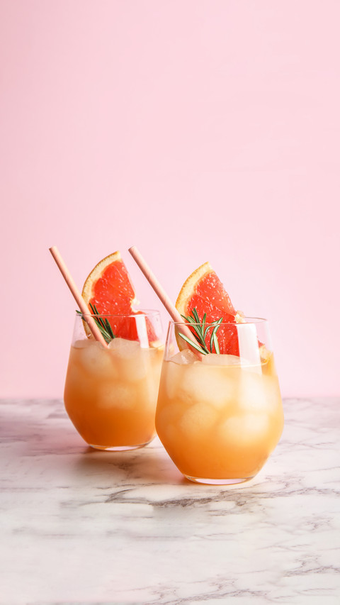 Glasses of grapefruit cocktails on table screenshot