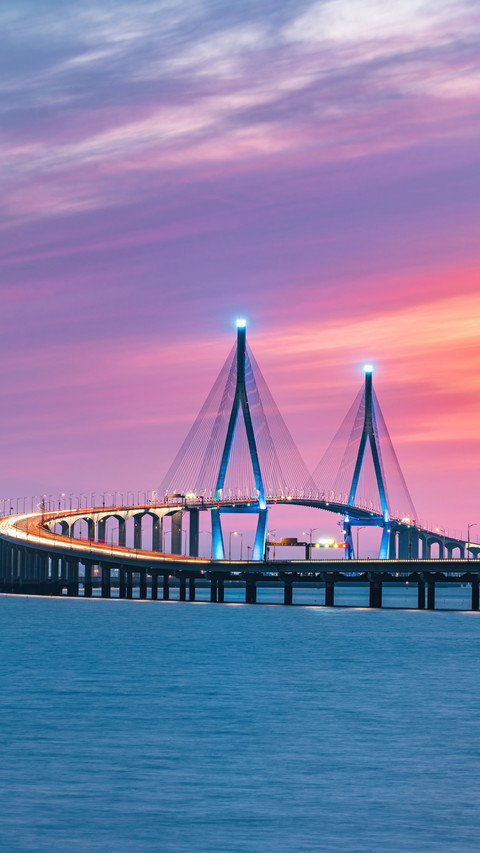 Curved Suspension Bridge, Lit Up in Blue at Dusk screenshot