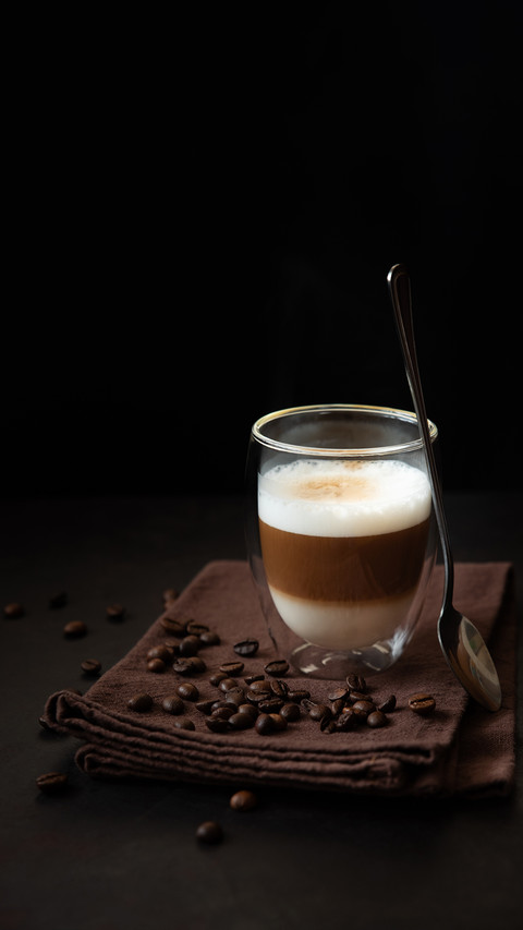 The thermo glass cup of latte coffee on dark wooden table screenshot