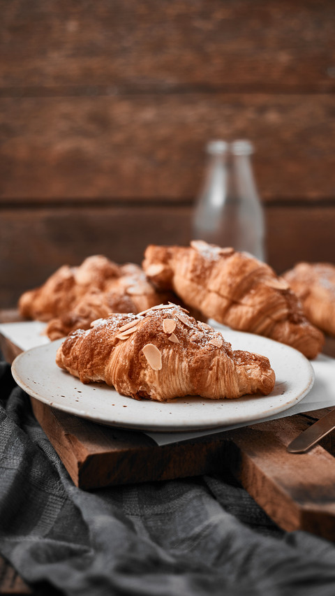 Almond croissant with custard filling on wood background screenshot
