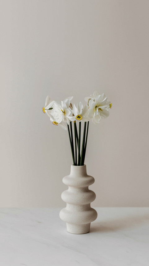 White Daffodils in Modern Vase on White Table screenshot