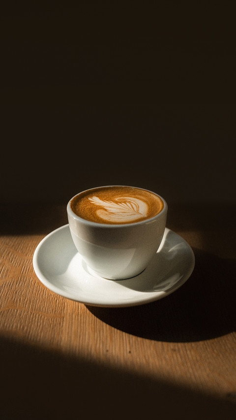 A coffee in a white cup on wooden table screenshot