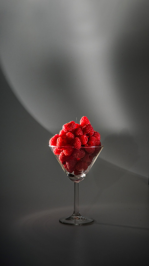 Fresh raspberries in glass beaker on white background screenshot
