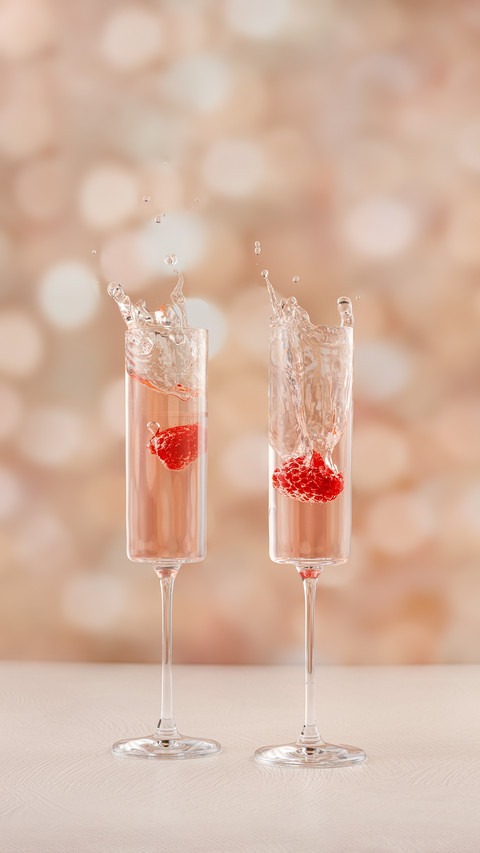Two Champagne Glasses Splashing with Fruit in It screenshot