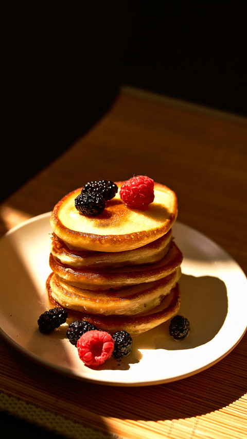 Pancakes with raspberry and honey on the white plate screenshot