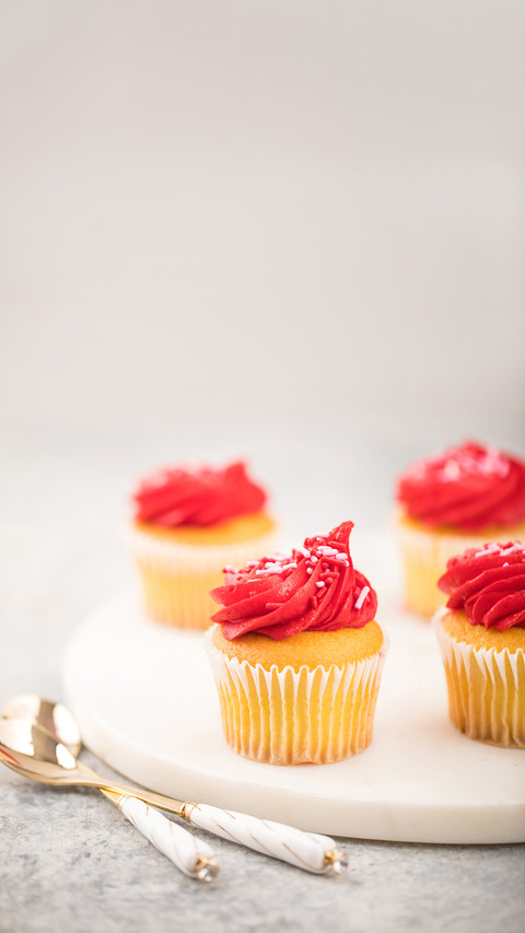Red frosting Valentines Day cupcakes on white marble tray screenshot