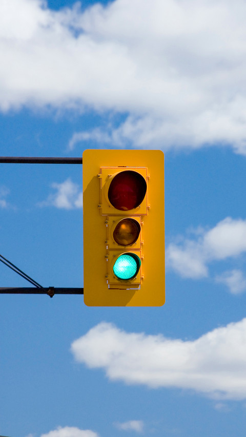 Traffic light against blue sky and clouds screenshot