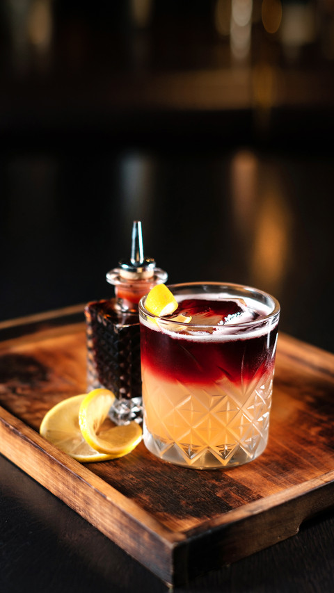 Cocktail on a wooden stand decorated with orange zest screenshot
