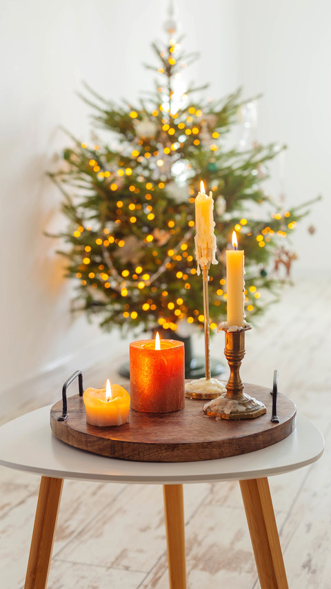 Burning candles on table on background christmas tree screenshot