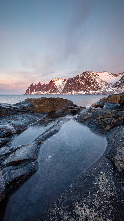 View over rocks and rockpools to snowy Oksen mountains screenshot