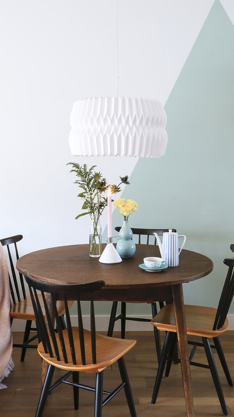 Round table and old chairs in front of twotone wall screenshot