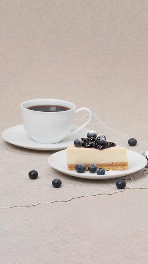 Cheesecake with blueberry jam and berries on white plate screenshot