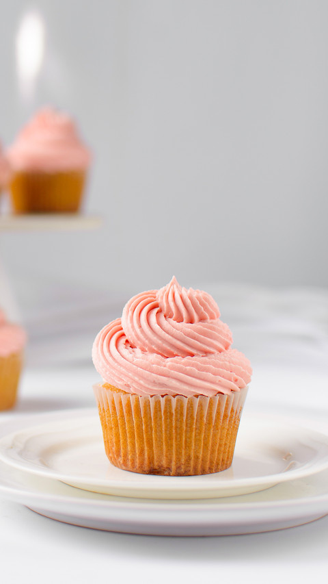 Vanilla cupcake with pink buttercream on a plate screenshot
