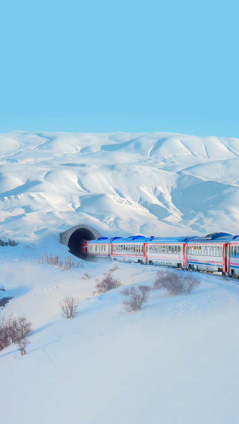Red diesel train in motion at the snow covered platform screenshot