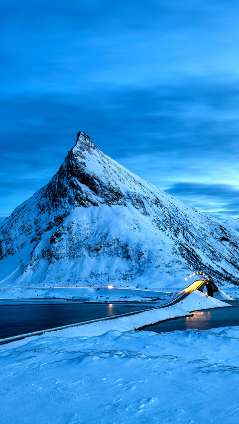 Fredvang Bridge set against pyramid shaped mountain at nigh screenshot