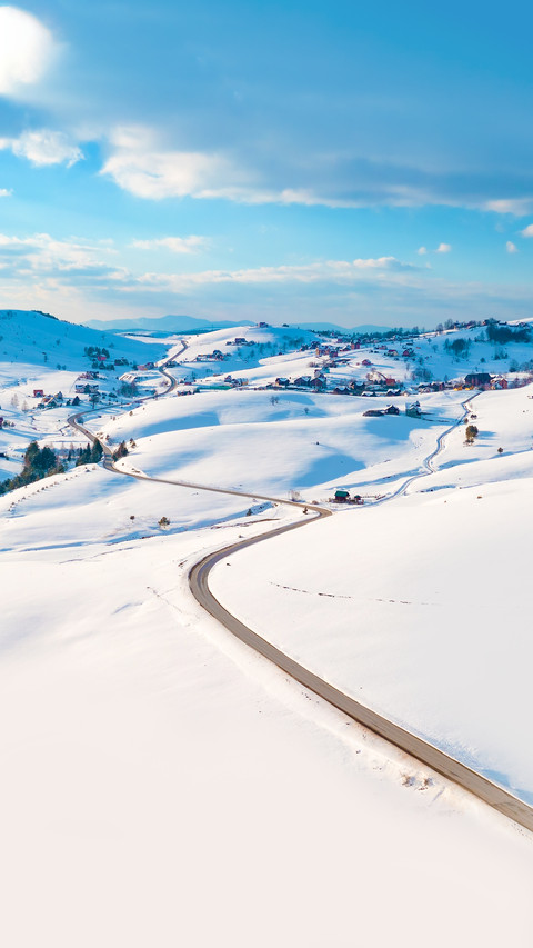 Aerial shot of winter road and frozen mountain creek screenshot