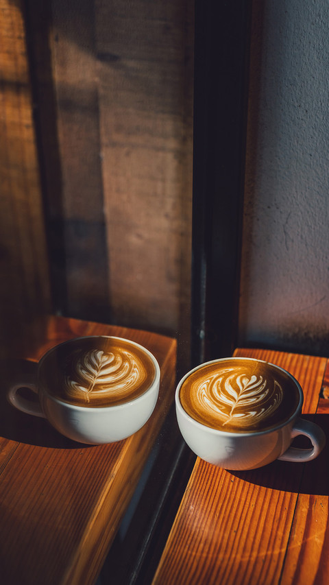 Coffee latte in sunshade on wood table screenshot