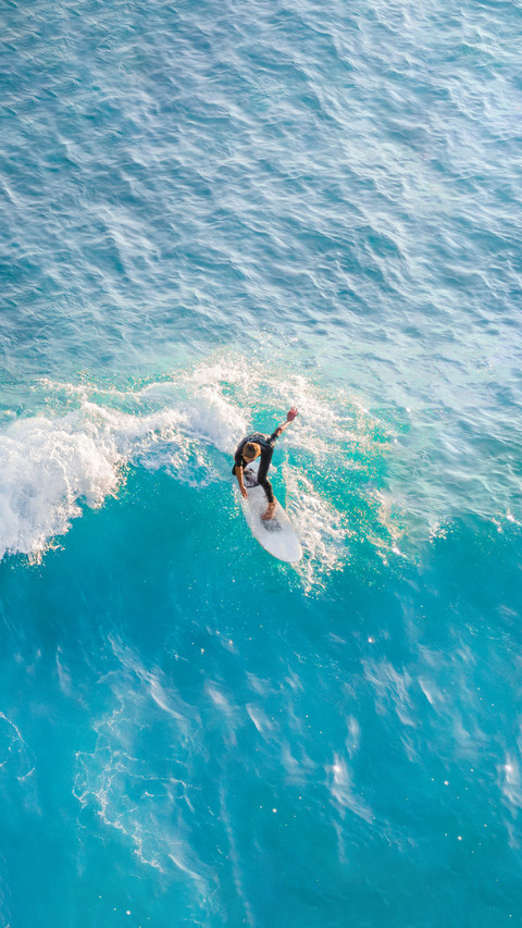 Surfer at the top of the wave in the ocean screenshot