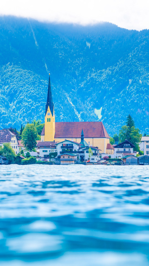 Church on other side of blue lake near mountains screenshot