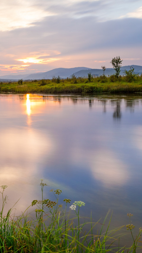 The slanting sun sets on the small river and the boats screenshot