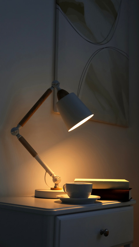Cup of drink and books on table in dark room screenshot