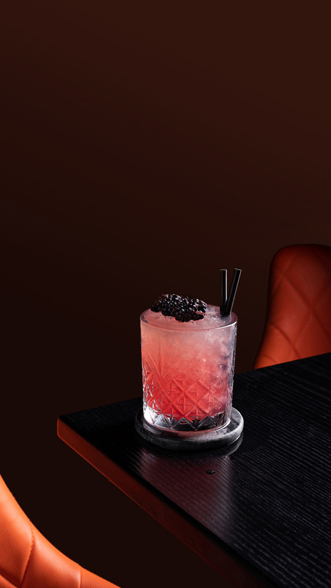 Negroni cocktail in dark bar with blackberries screenshot