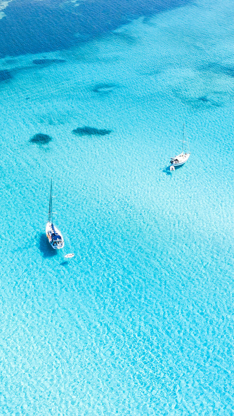 Aerial view of boats sailing on turquoise water screenshot