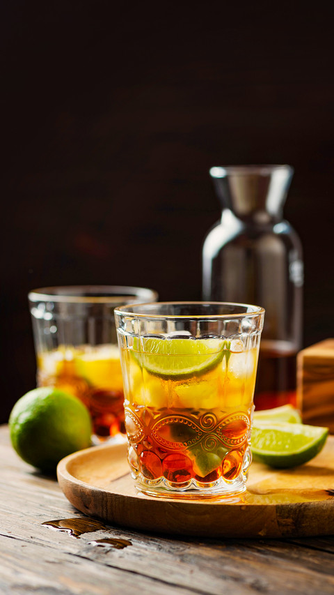Strong golden rum with lime and ice, selective focus screenshot