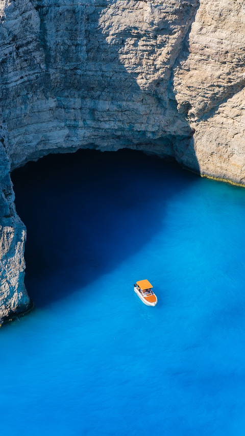 View Of The Sea Bay And A Lone Boat From A Drone screenshot