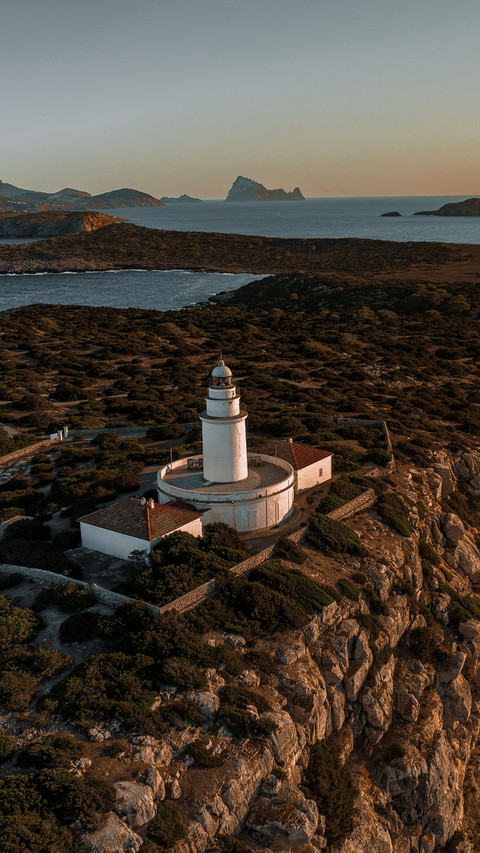 Lighthouse at Sunset on a Tall Cliff Overlooking screenshot