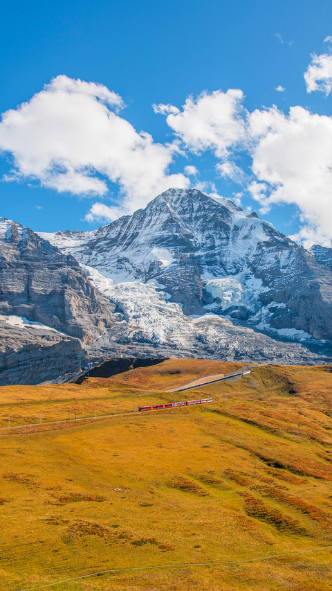 Landscape photo of Swiss Alps with clouds and meadow screenshot