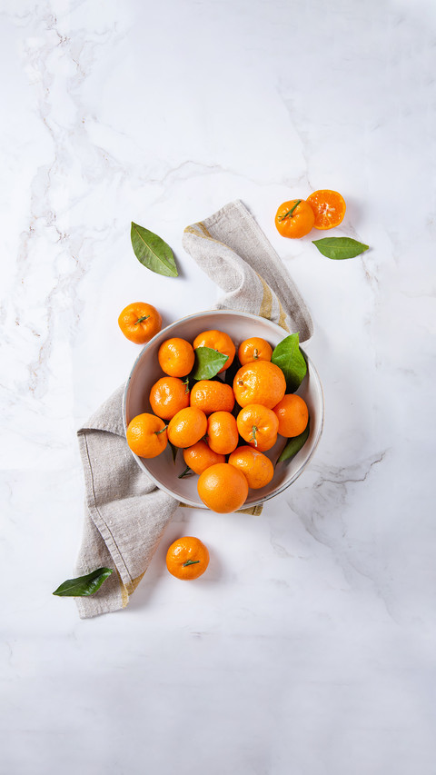 Sweet tangerines in a ceramic bowl with linen napkin screenshot