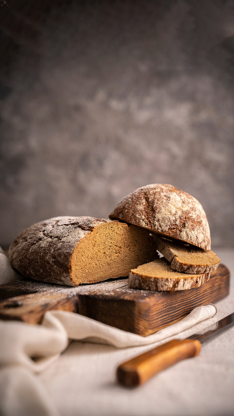 Sliced loaf of black bread on the wooden cutting board screenshot